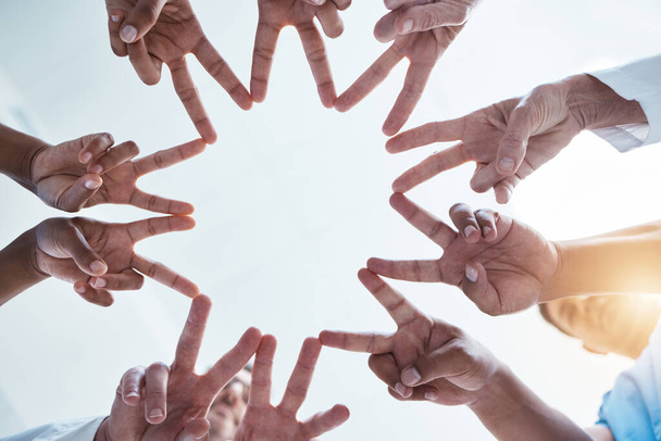 Peace, team building and hands of business people with star shape using teamwork, support and global solidarity. Collaboration, below and group of workers in a huddle with our vision in a company. - Photo, Image