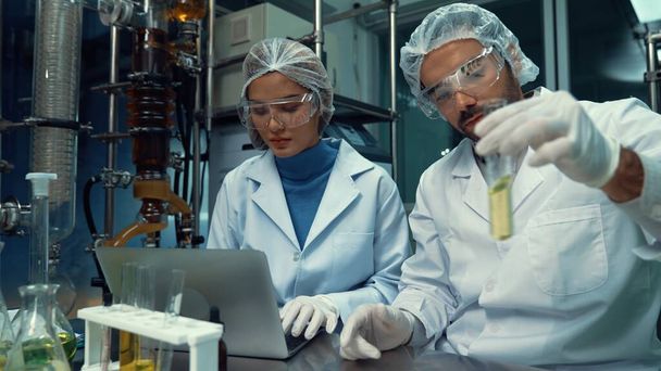 Két hivatásos egyenruhás tudós, akik vegyi és orvosbiológiai kísérleteket végeznek laboratóriumban. - Fotó, kép
