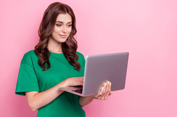 Photo of pretty positive focused woman with wavy hairdo dressed green t-shirt writing email hold laptop isolated on pink color background. - Φωτογραφία, εικόνα