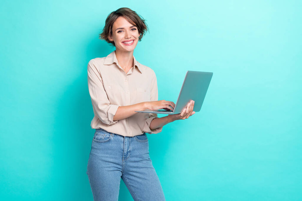 Photo of young charming attractive businesswoman using her laptop count financial profit good mood positive isolated on aquamarine color background. - Fotó, kép