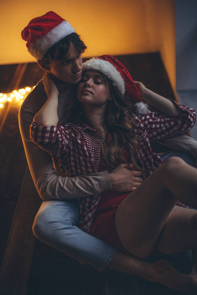 Romantic couple in love feel happiness from their romance while spending Christmas together, woman and man enjoying perfect relationship in cozy home interior. High quality photo - Photo, Image