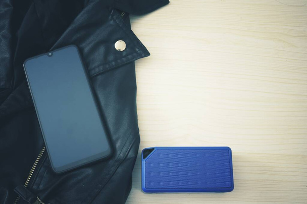 Bluetooth speaker and smartphone on leather jacket - Photo, Image