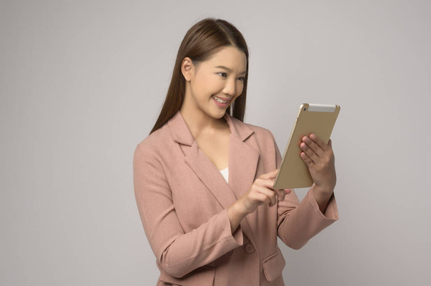 A Young asian woman using tablet over white background, technology concept. 	 - Fotó, kép