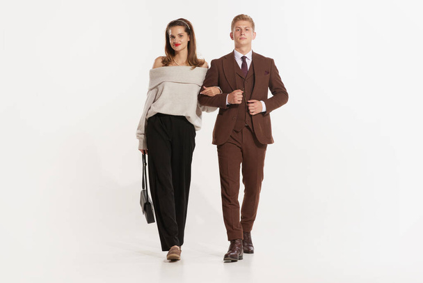 Full length photo of two elegant lovely partners walking isolated on white studio background. Young retro man and woman. Concept of senior people, family, love, vintage, couple, lifestyle - Zdjęcie, obraz