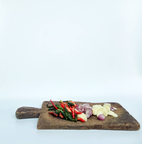 gesneden ui, knoflook en chili op houten snijplank, geïsoleerd op witte ondergrond - Foto, afbeelding