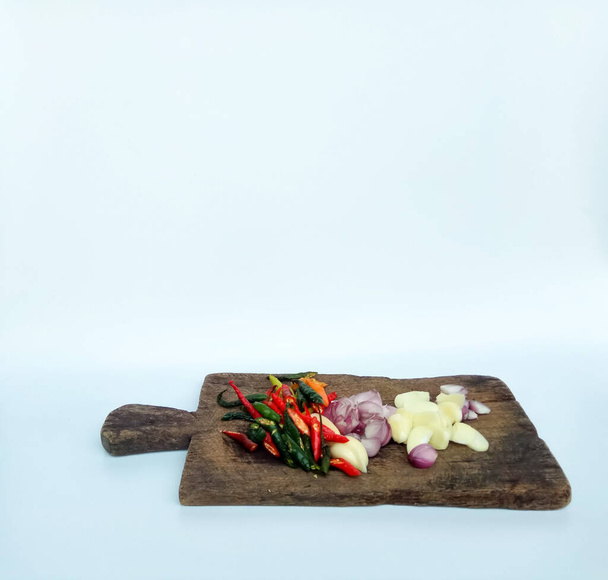 Κομμένο κρεμμύδι, σκόρδο και τσίλι σε ξύλο κοπής, απομονώνονται σε λευκό φόντο - Φωτογραφία, εικόνα