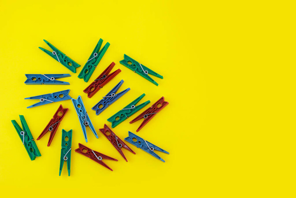 plastic clothespins for fastening washed laundry on a yellow background - Photo, image