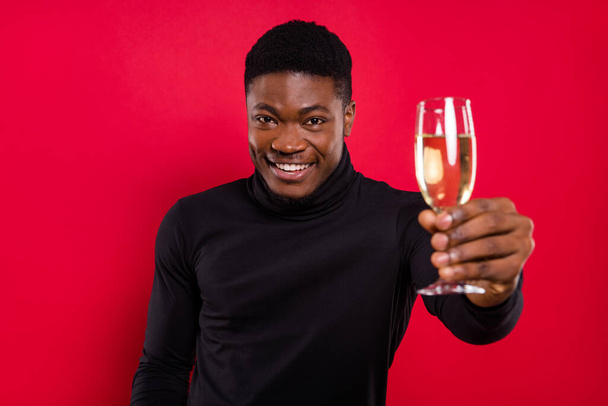 Portrait of attractive trendy cheerful guy drinking champagne birthday day celebratory isolated over vivid red color background. - Fotografie, Obrázek