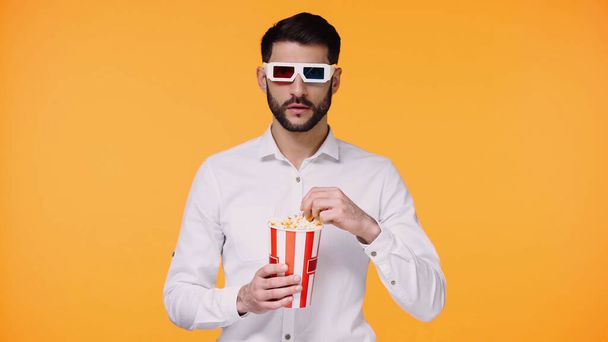 бородатый человек в 3D очки с ведром с попкорном изолированы на желтый - Фото, изображение