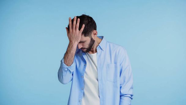 displeased bearded man in shirt touching head with hand isolated on blue  - Foto, afbeelding