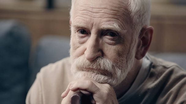triste hombre mayor con barba sentado con bastón solo   - Foto, Imagen