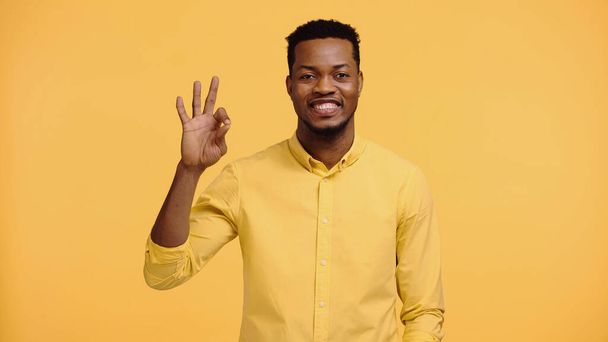 positive african american man in shirt showing ok sign isolated on yellow  - Φωτογραφία, εικόνα