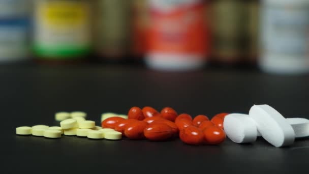 Medicamentos o suplementos dietéticos en un fondo negro y frascos con pastillas - Metraje, vídeo