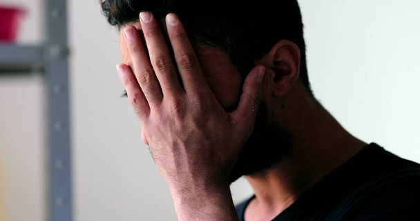 Беспокойный мужчина касается лица и шеи в отчаянии - Фото, изображение