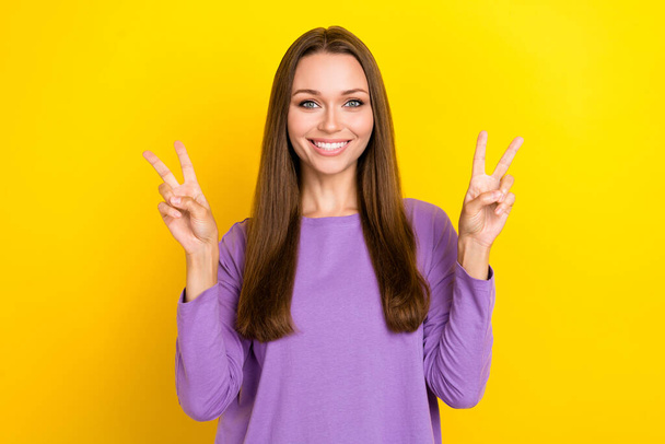 Photo of attractive charming peaceful businesswoman wear trendy pullover toothy smiling showing v-sign popular symbol isolated on yellow color background. - Valokuva, kuva