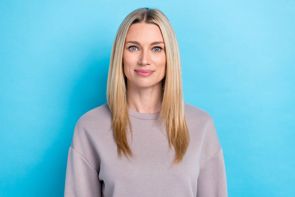 Portrait of positive cute lady calm serious face dressed trendy pullover isolated on blue color background. - Фото, изображение