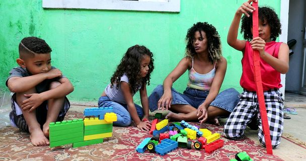 Дети из Латинской Бразилии играют на улице рядом с матерью - Фото, изображение