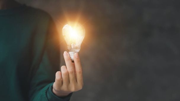 Woman holding glowing lamp, Creative new idea. Innovation, brainstorming, strategizing to make the business grow and be profitable. Concept execution, strategy planning and profit management. - Photo, Image