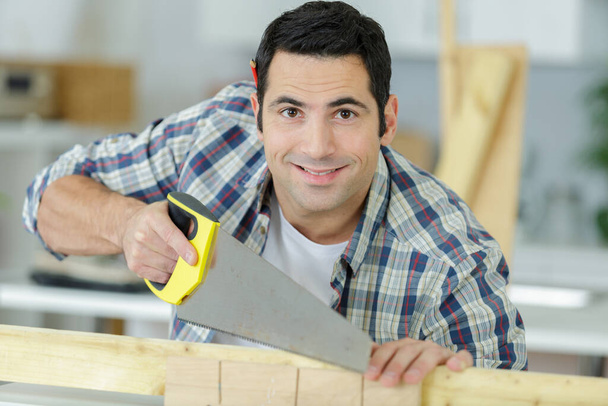 a happy carpenter holding planks - Фото, зображення