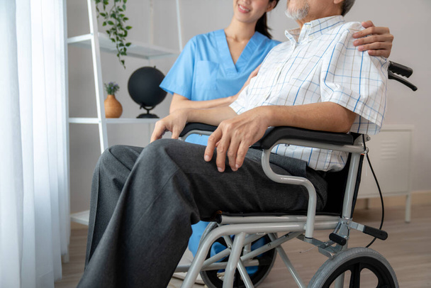 Догляд за медсестрою і задоволеним старшим чоловіком в інвалідному кріслі вдома, будинок престарілих. Медицина для літніх людей старшого віку, догляд за домом для пенсіонерів
. - Фото, зображення