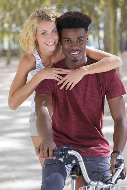 cheerful woman riding on back of boyfriends bicycle - Foto, imagen