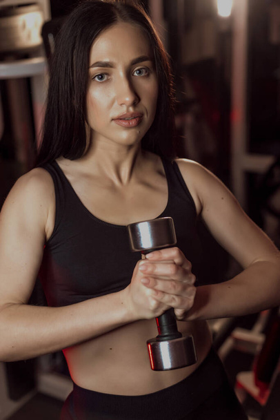 beautiful and athletic girl is working out in the gym on the simulator - Fotografie, Obrázek