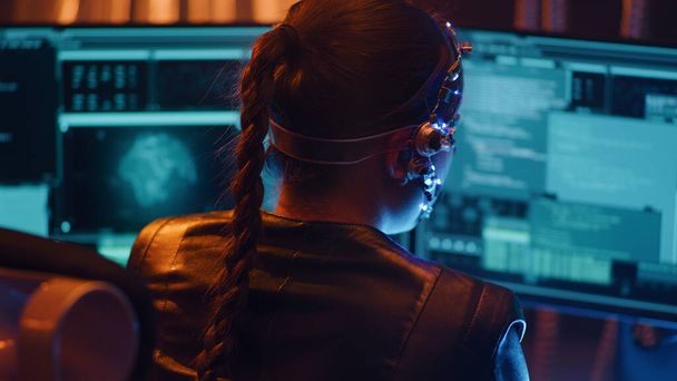 Widok tyłu Cyberpunkowej dziewczyny na klawiaturze. Wiele ekranów komputerowych z kodami przed nią. Devloping kody dla futurystycznego oprogramowania. Neonowe światła w tle. - Zdjęcie, obraz