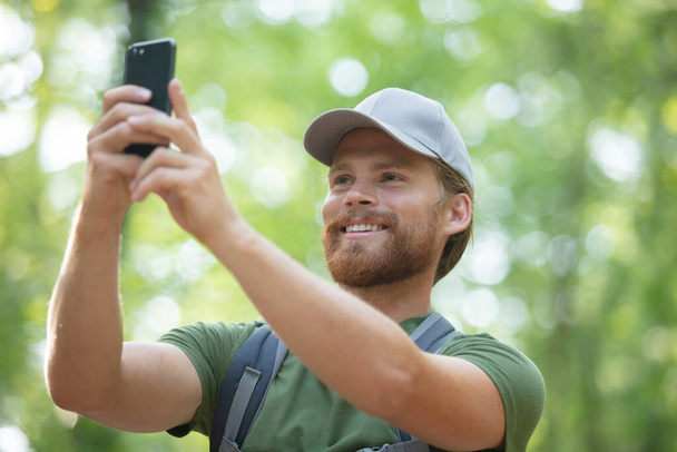 Jonge man het nemen van een selfie in het bos - Foto, afbeelding