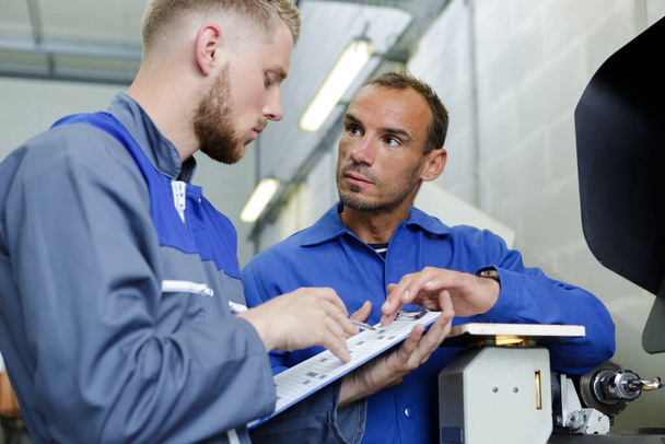 two specialist repairmen in blue overall talking - Foto, immagini