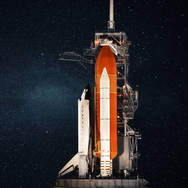 Space Shuttle steht am Sockel und bereitet sich auf den Start vor dem Hintergrund des Sternenhimmels vor. Raumfahrtrakete, Konzept - Foto, Bild
