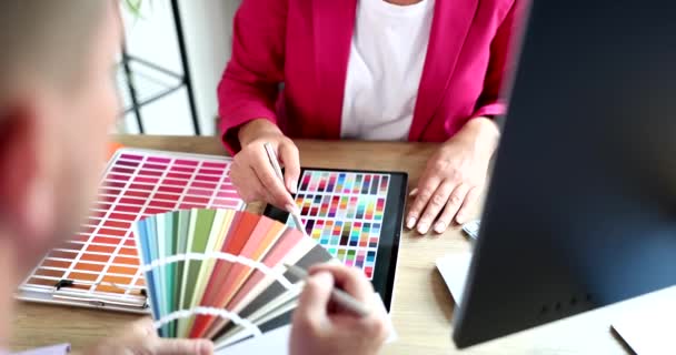 Γυναίκα που εργάζεται με χρωματική παλέτα και tablet στο γραφείο συζητώντας την επιλογή χρώματος με τον πελάτη. Επιλογή αποχρώσεων και χρωμάτων στην εφαρμογή για κινητά και χρωματική παλέτα - Πλάνα, βίντεο