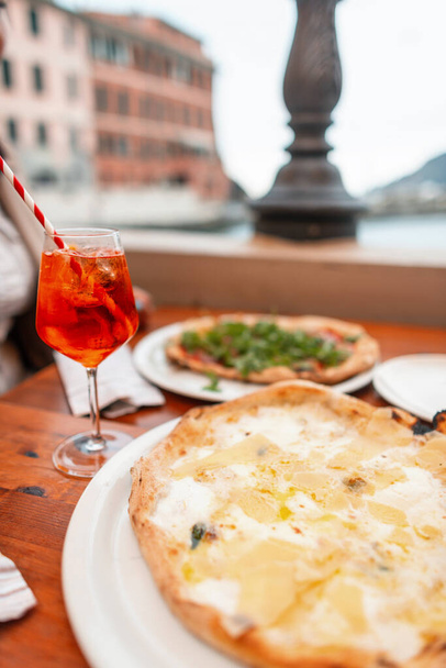 Herkullinen juustoinen italialainen kansallinen pizza aperolilla ravintolassa ulkona, matka Italiaan. Syksyn loma Veranziossa. Herkullista italialaista ruokaa - Valokuva, kuva