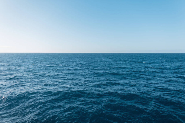 Prachtig uitzicht op blauw helder water met golven en een heldere horizon. Reizen en zomervakantie. Zee, water en lucht - Foto, afbeelding