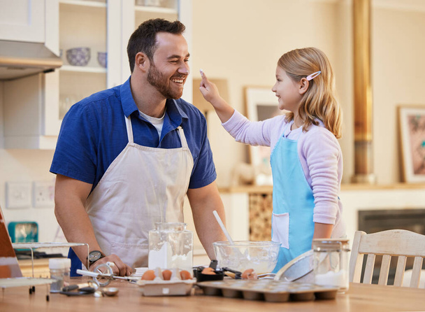 Είσαι τόσο αστείος μπαμπά. ένας νεαρός πατέρας και η κόρη παίζουν γύρω ενώ το μαγείρεμα - Φωτογραφία, εικόνα