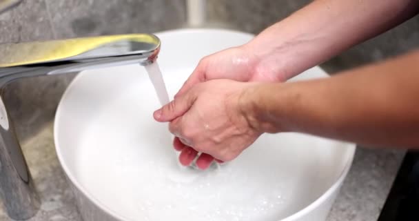 Ο άνθρωπος πλένει τα χέρια του από κοντά την βρύση χωρίς επαφή. Έννοια υγιεινής χεριών - Πλάνα, βίντεο