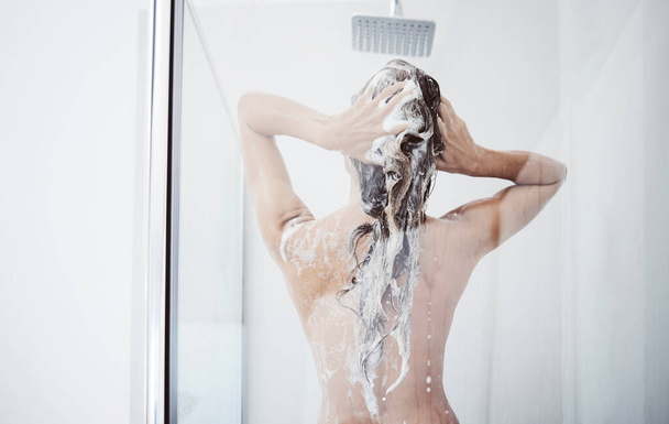 Adoro la pelle. una donna che si lava i capelli sotto la doccia - Foto, immagini