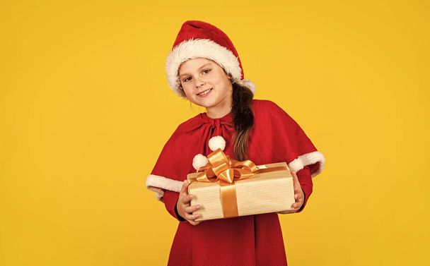 My happy day. Xmas gift shopping. Little girl Santa hat hold gift box. Kid hold present box yellow background. Gift package. Merry Christmas and happy holidays. Winter holidays. Wish list concept. - Foto, Imagen
