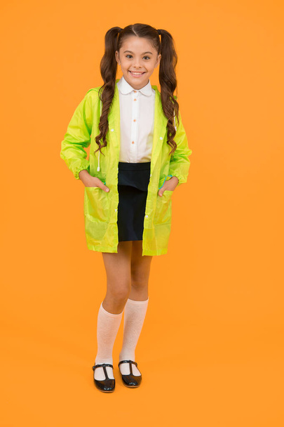 Waterproof accessories make rainy fall day cheerful and pleasant. Schoolgirl in green cloak. Waterproof accessory. Kid girl happy wear waterproof cloak. Enjoy fall weather with proper garments. - Foto, Imagem