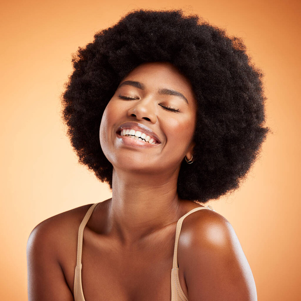 Black woman face, natural beauty and skincare health wellness on orange studio wall background. A happy african model smile, black female empowerment and healthy cosmetic luxury fashion afro haircare. - Foto, immagini