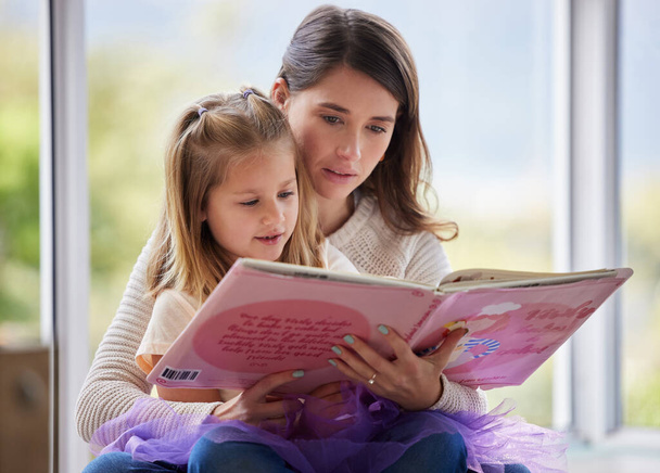 Está na hora da história. uma jovem mãe lendo um livro com sua filha em casa - Foto, Imagem