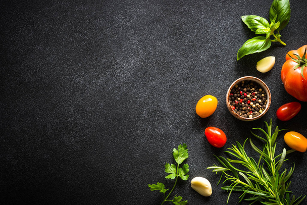 Essen Hintergrund auf schwarzem Stein Tisch mit frischem Gemüse, Kräutern und Gewürzen. Zutaten zum Kochen mit Kopierraum. - Foto, Bild