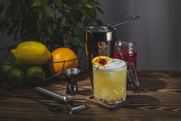 Whiskey Sour Cocktail em vidro antiquado com gotas de água na mesa em casa real. Novo conceito de vida de quarentena. Close up, profundidade rasa do campo - Foto, Imagem
