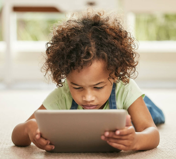 Es gibt nichts, wofür eine Tablette nicht hilfreich wäre. ein kleines Mädchen, das zu Hause ein digitales Tablet benutzt - Foto, Bild