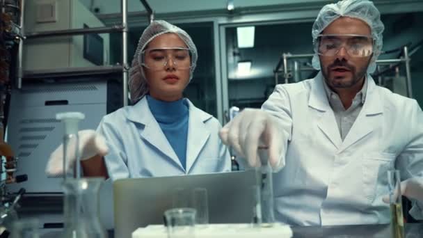 Two scientist in professional uniform working in curative laboratory for chemical and biomedical experiment - Footage, Video