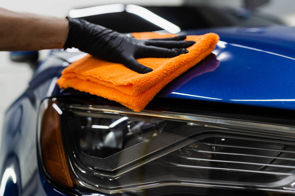 Hand car drying with microfiber in detailing auto service. Cleaner worker dry body car after washing automobile - Photo, Image