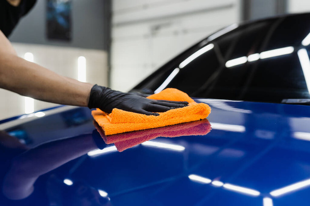Secagem de carro de mão com microfibra em detalhar o serviço de auto. trabalhador mais limpo carro corpo seco após a lavagem automóvel - Foto, Imagem