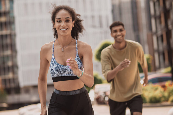 Marathon. Zwei junge Leute rennen und lächeln - Foto, Bild