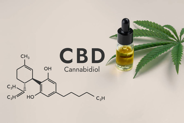 CBD oil in a clear, glass bottle with a dropper lid, isolated on a white background and biochemistry formula hexagon illustration, to represent the legalized marijuana extracts concept. - Photo, image