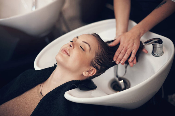 Il n'y a rien que j'aime plus qu'un bon massage de la tête. une belle jeune femme se fait laver les cheveux au salon - Photo, image