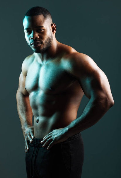All the muscle a man could ever want. Studio shot of a handsome and muscular young man posing against a green background - Foto, Imagem
